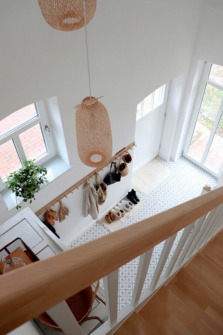 Bright entrance area with wardrobe and rattan lamps with staircase