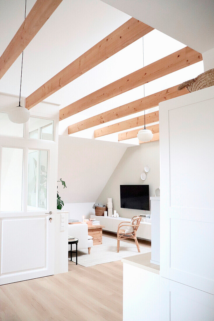 Bright living room with roof beams and minimalist furnishings