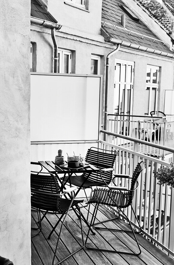 Tisch mit Stühlen auf dem Balkon (s-w-Aufnahme)