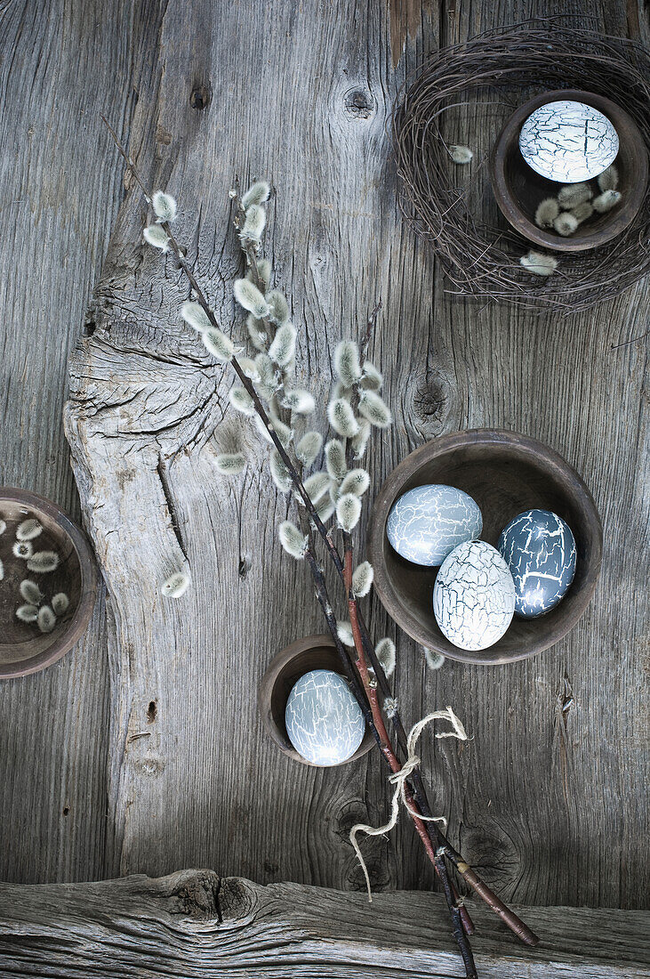 Hand-painted Easter eggs on willow twigs and cloth on wood