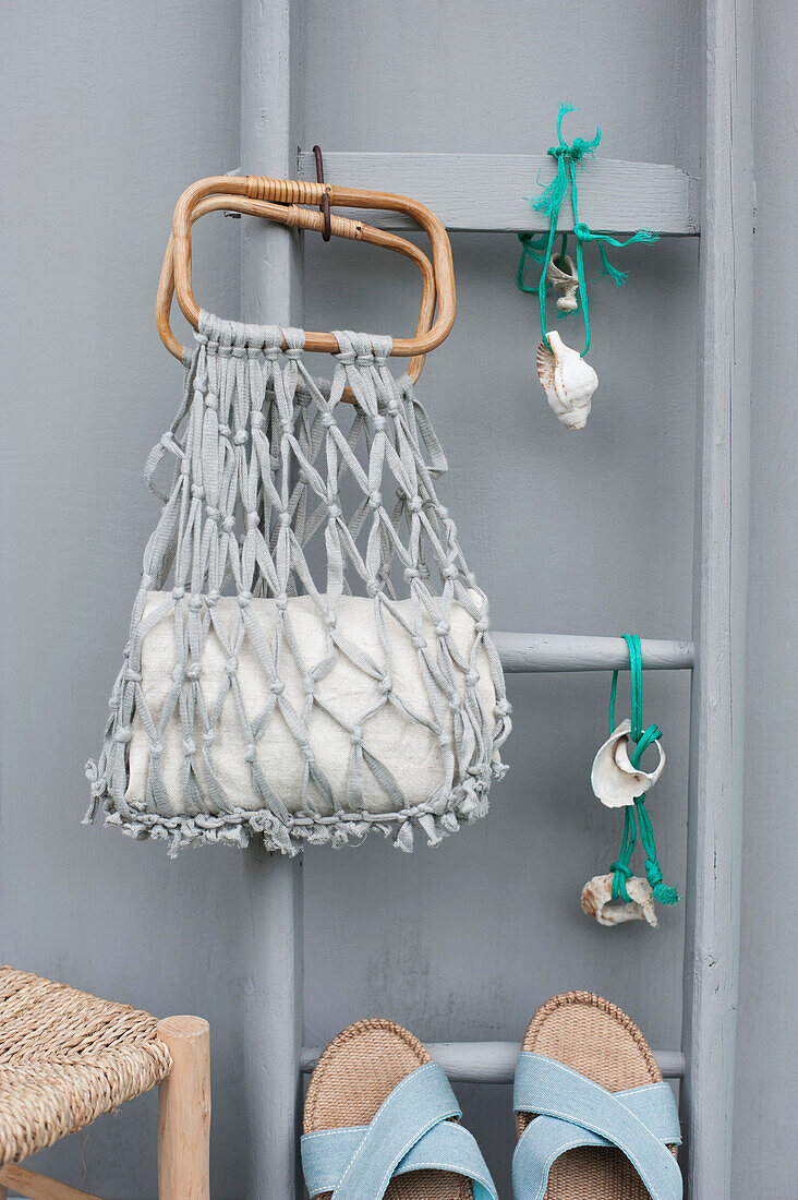 DIY-Makramee-Netztasche, Handtuch, Leiter, Schnüre mit Muscheln und ein Paar Sandalen