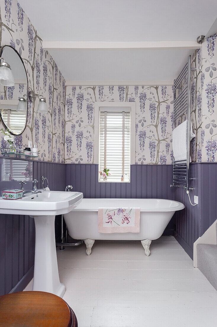 Bathroom with freestanding bathtub and floral wallpaper