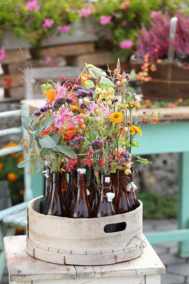 Zinnias, woodland vine fruit stands, sage, water asters, physalis and berry branches in bottles