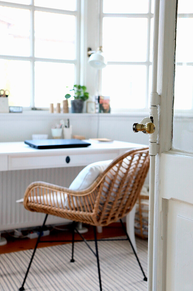 Rattan chair in front of a window in the bright study