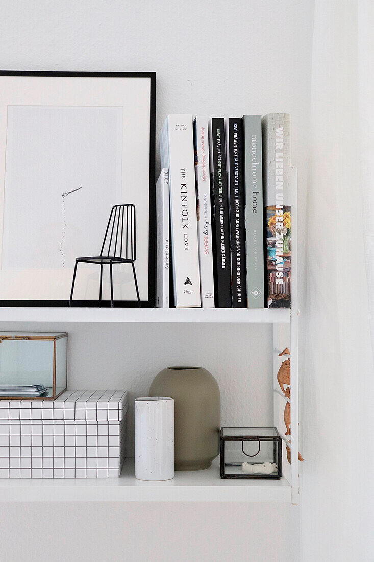 Minimalist, white wall shelf with books and decorative objects