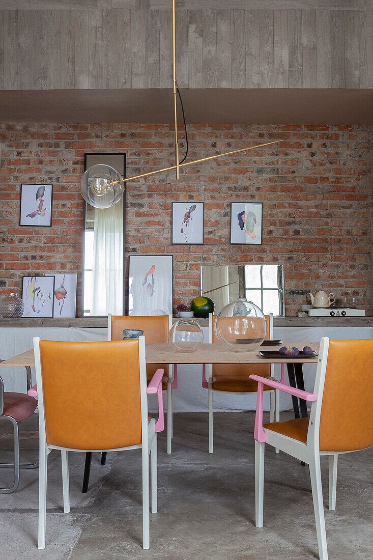 Dining area with leather chairs, modern light and brick wall