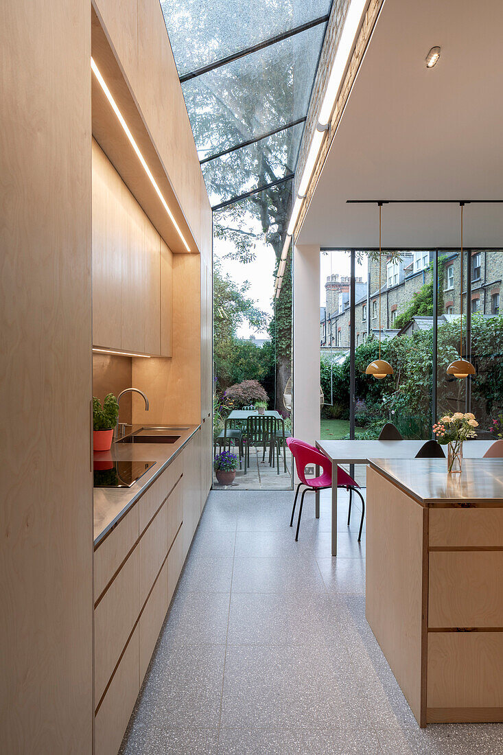 Offene Küche mit Mittelblock und Essbereich, Glasdach und Gartenblick