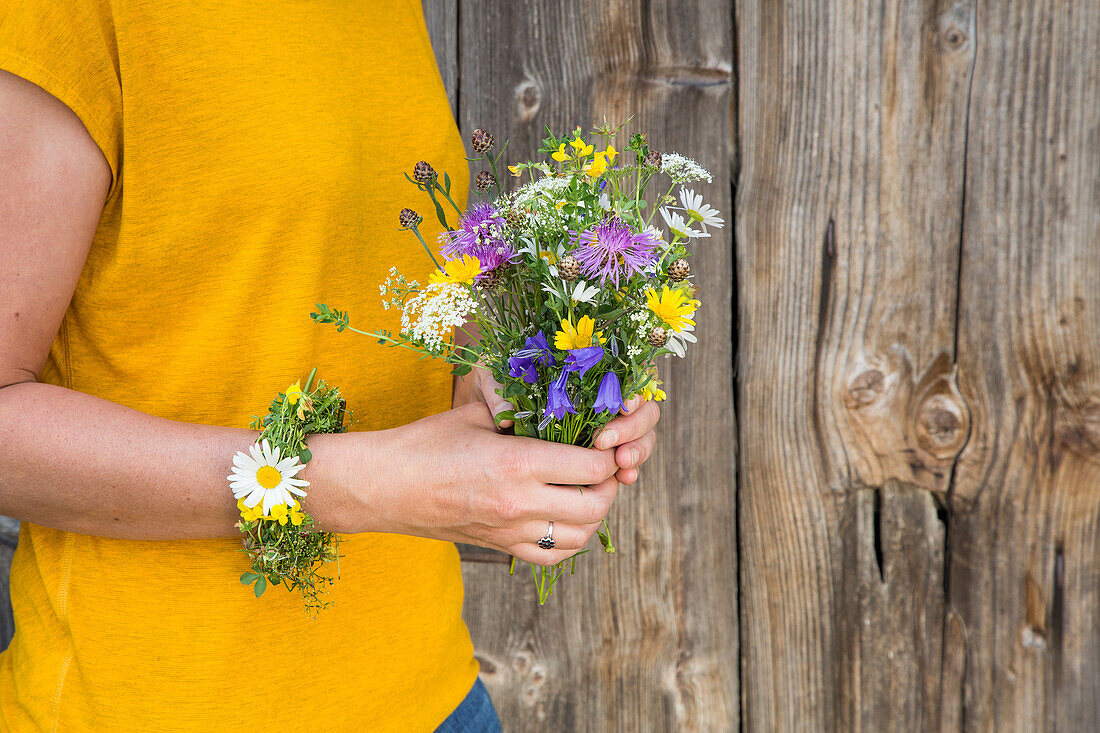 Person hält bunten Wildblumenstrauß in den Händen