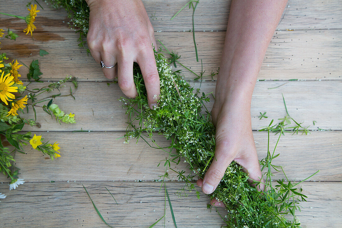 Herstellung eines Kranzes aus Gräsern und Wiesenblumen