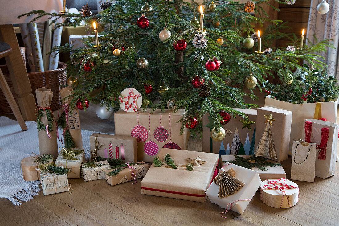 Weihnachtsbaum mit Geschenken und roten Kugeln in einem Wohnzimmer