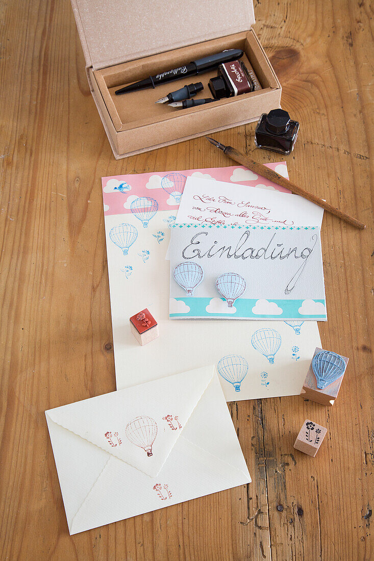 Invitation card set with hot air balloon motif, quill and inkwell