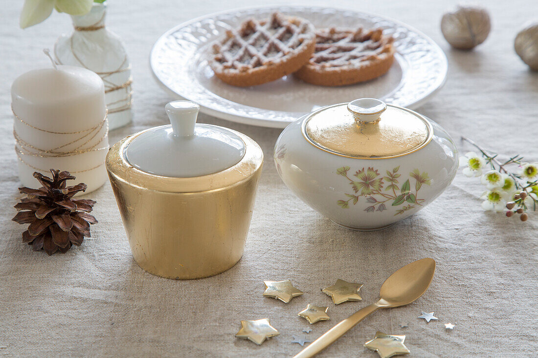 Christmas table setting with sugar bowls, patries and decorative stars