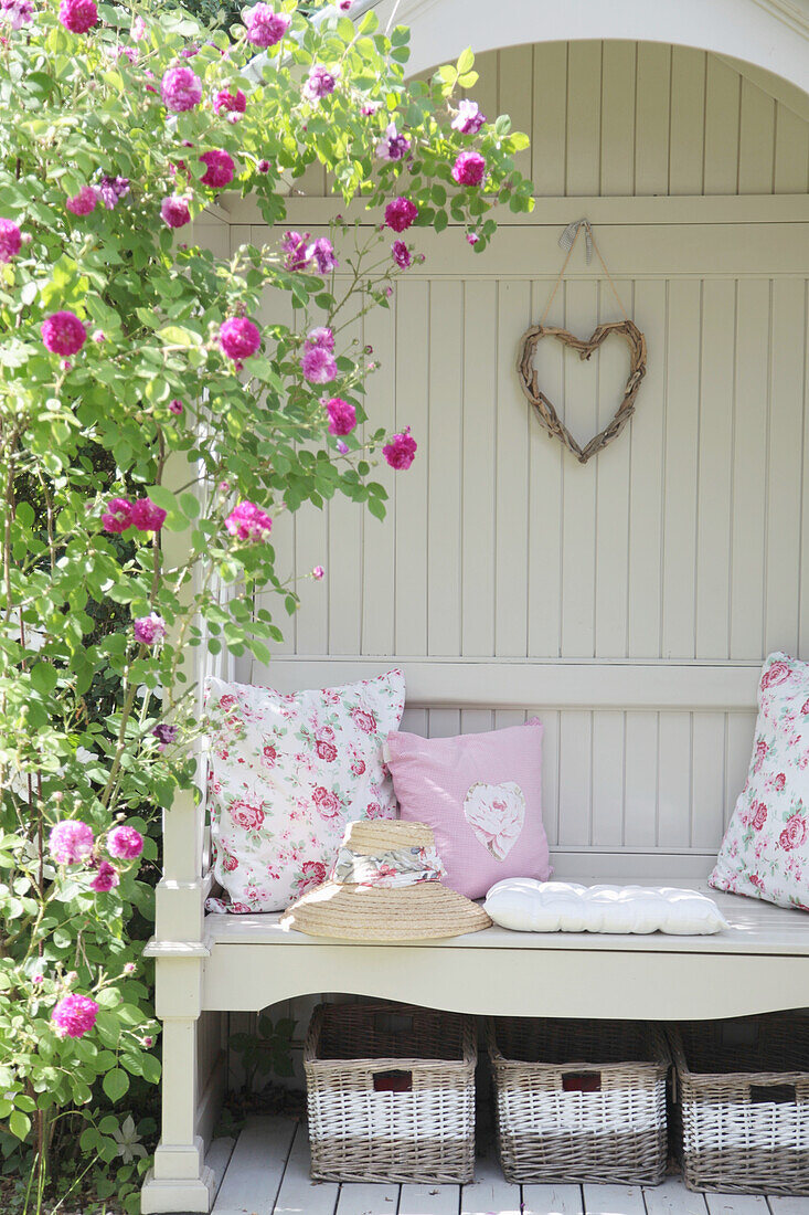 Arbour bench with climbing rose 'Himmelsauge' and rose-patterned cushions