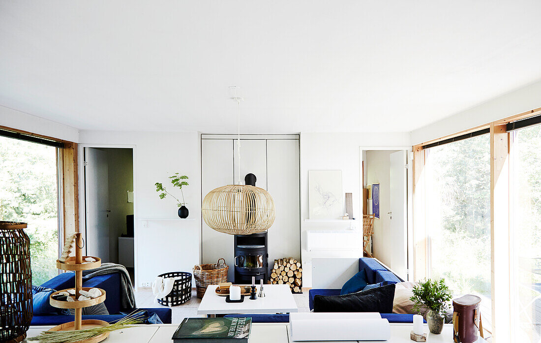 White living room with blue sofas, fireplace and bamboo accessories