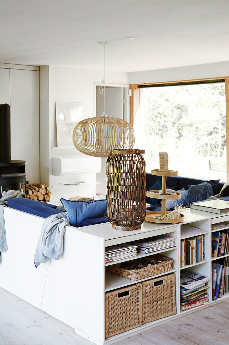 White shelf unit behind the sofa and bamboo lamp