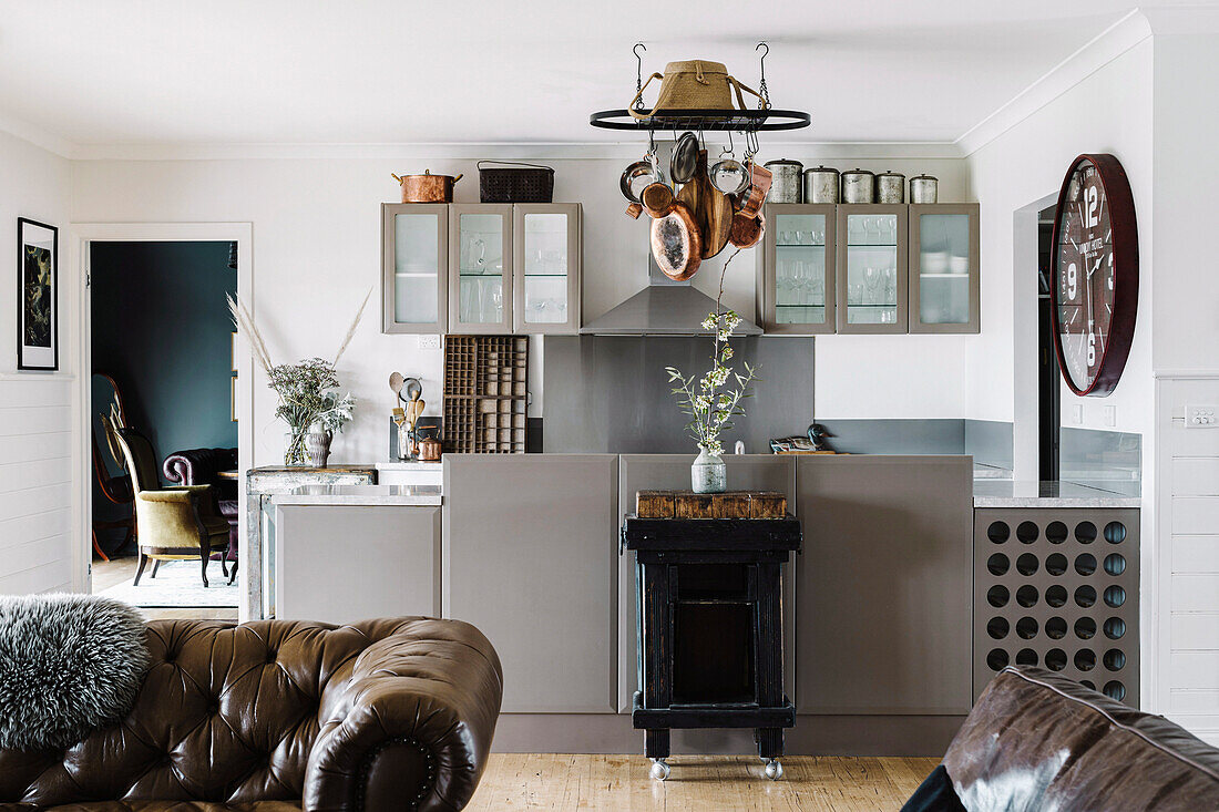 Kitchenette with grey fronts in the open plan living room with vintage décor