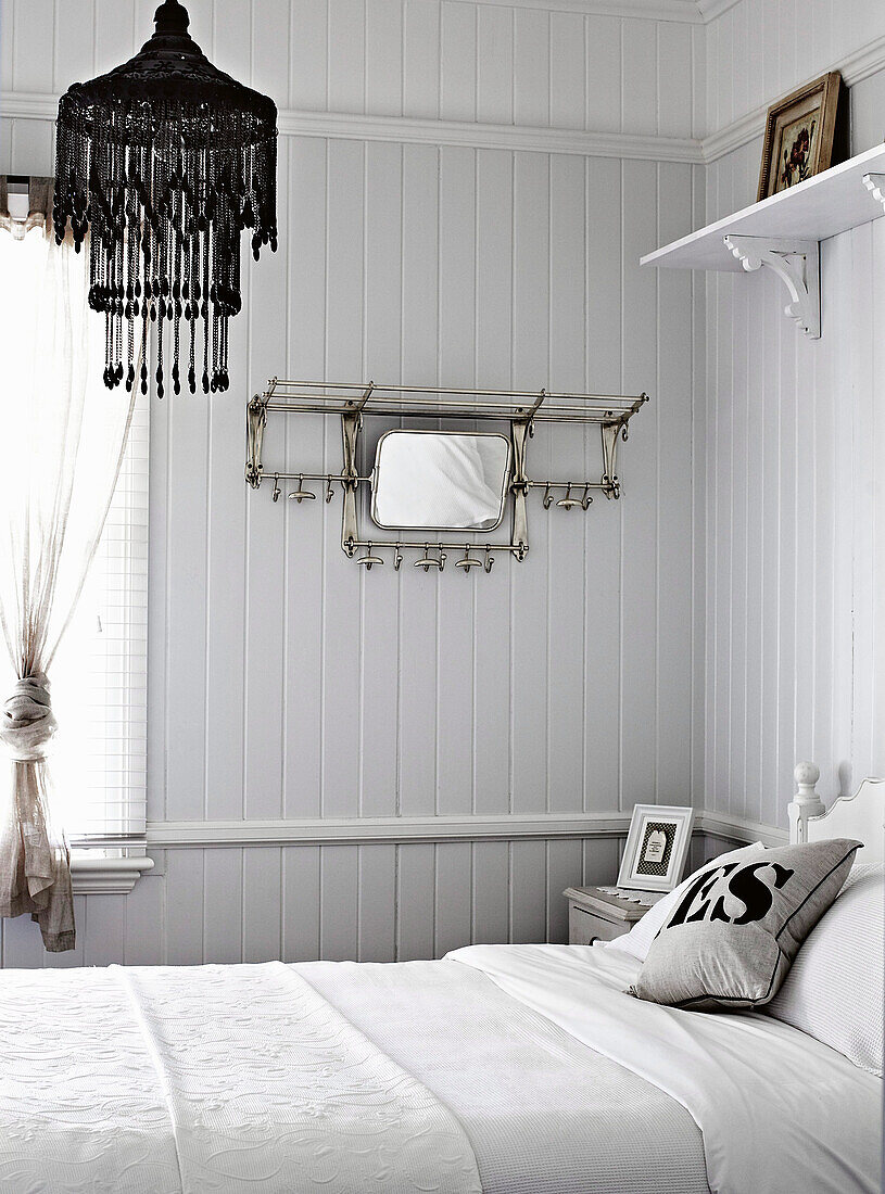 Doppelbett im weißen Schlafzimmer mit Holzverkleidung