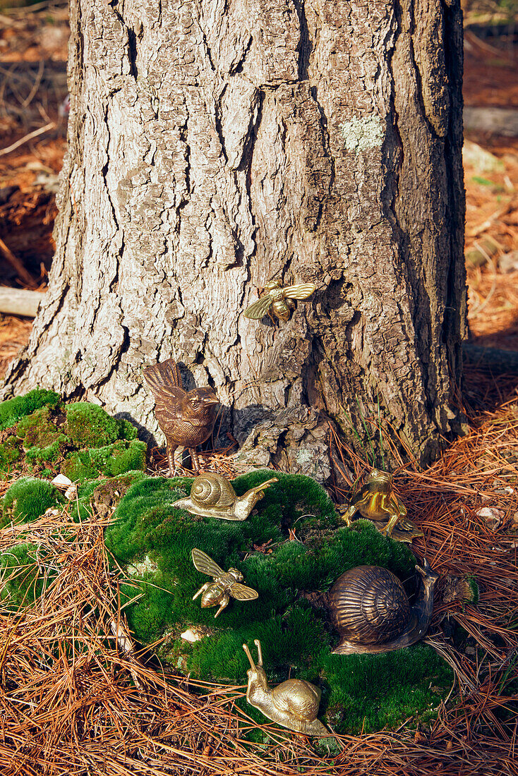 Dekovogel und Dekoschnecken auf Moos auf Waldboden