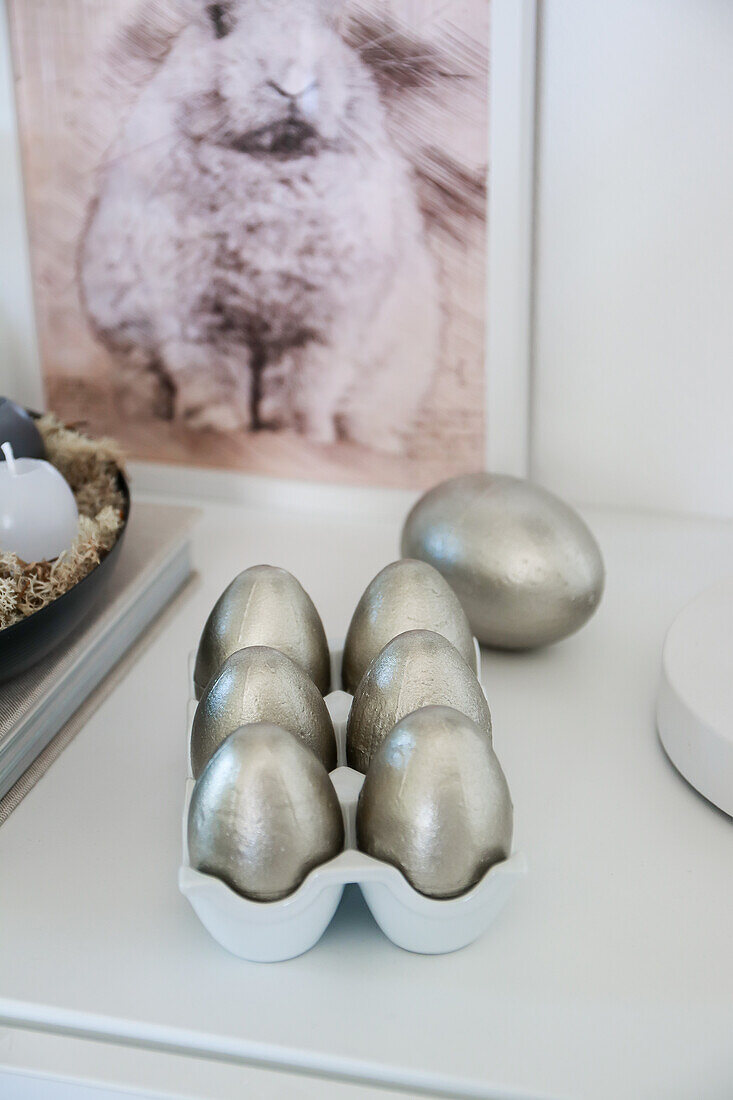 Silver Easter eggs in front of a bunny picture