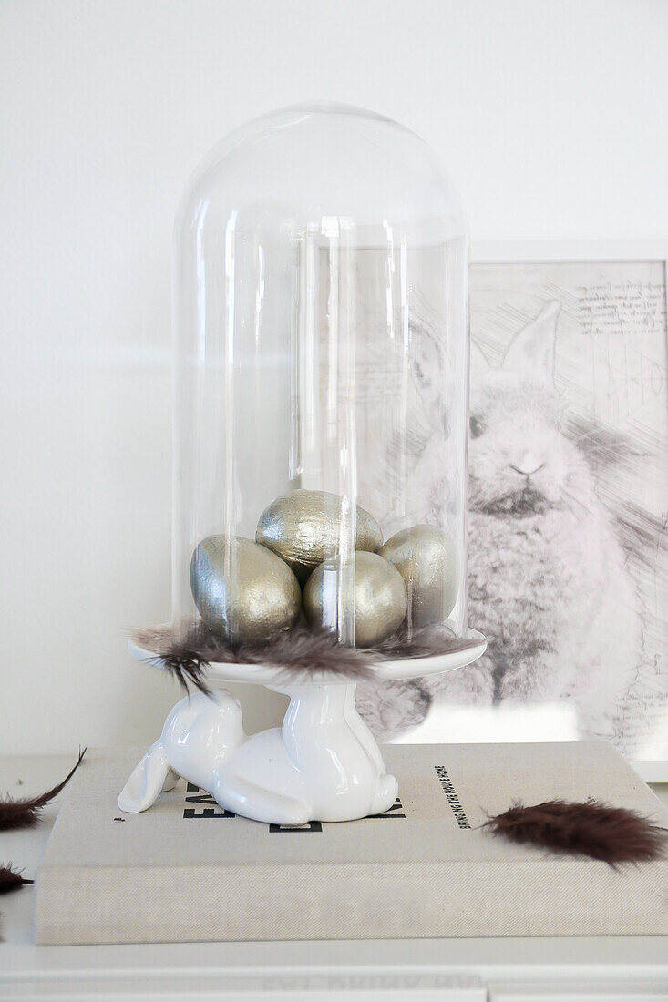 Easter decoration with silver eggs under a glass bell jar