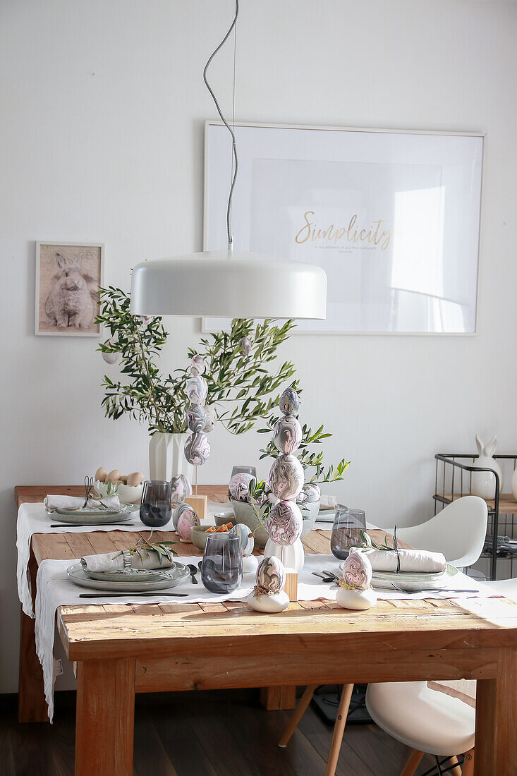 Festive table setting with Easter decorations and olive branches