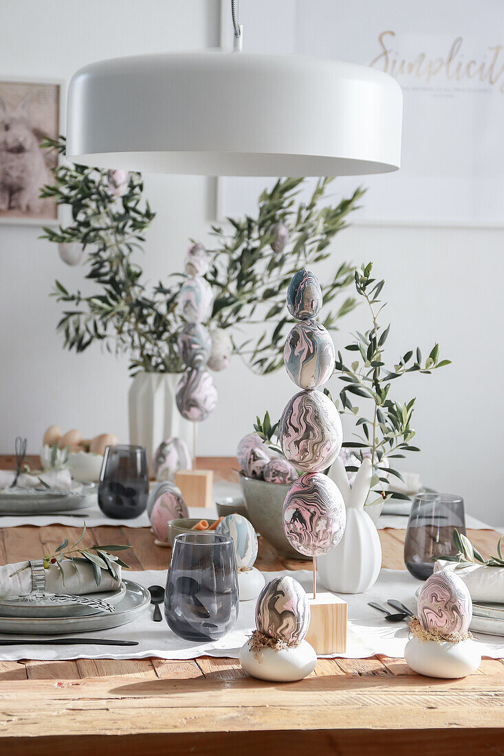 Easter table decoration with marbled eggs and olive branches