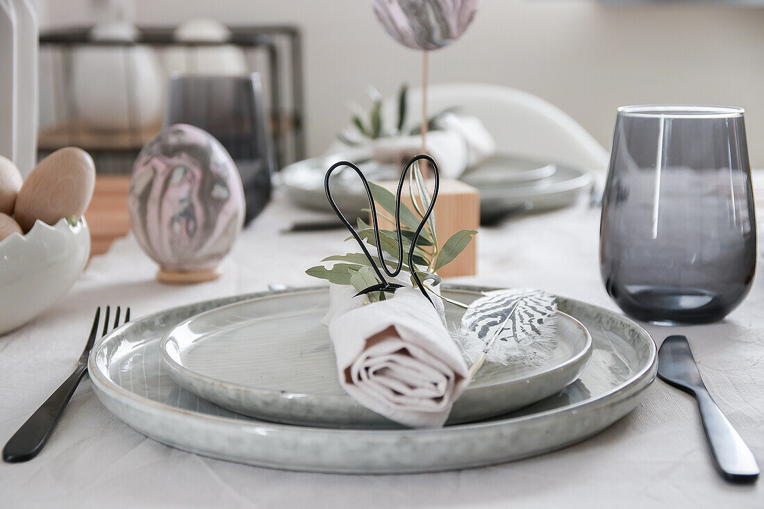 Easter table setting with eggs, feathers and napkin ring with bunny ears