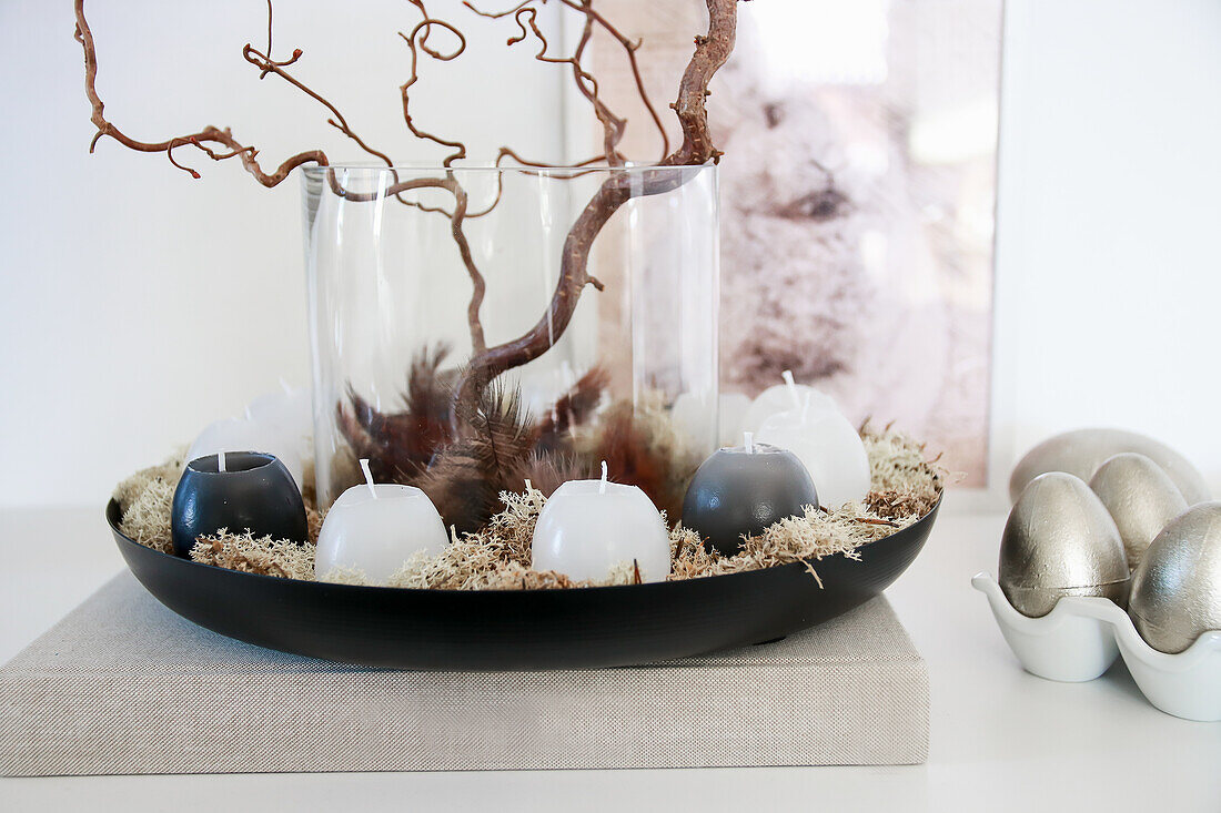 Candle arrangement with moss and branches, bunny picture and silver eggs for Easter