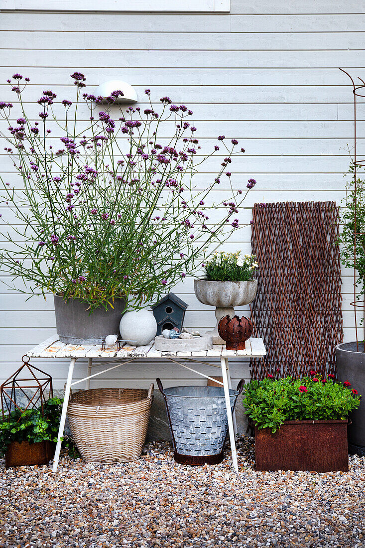 Small table with garden ornaments and potted verbena