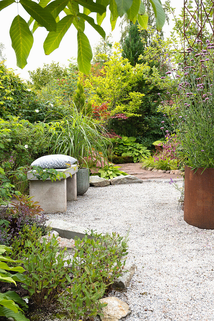 Winding garden path with stone bench and diverse planting