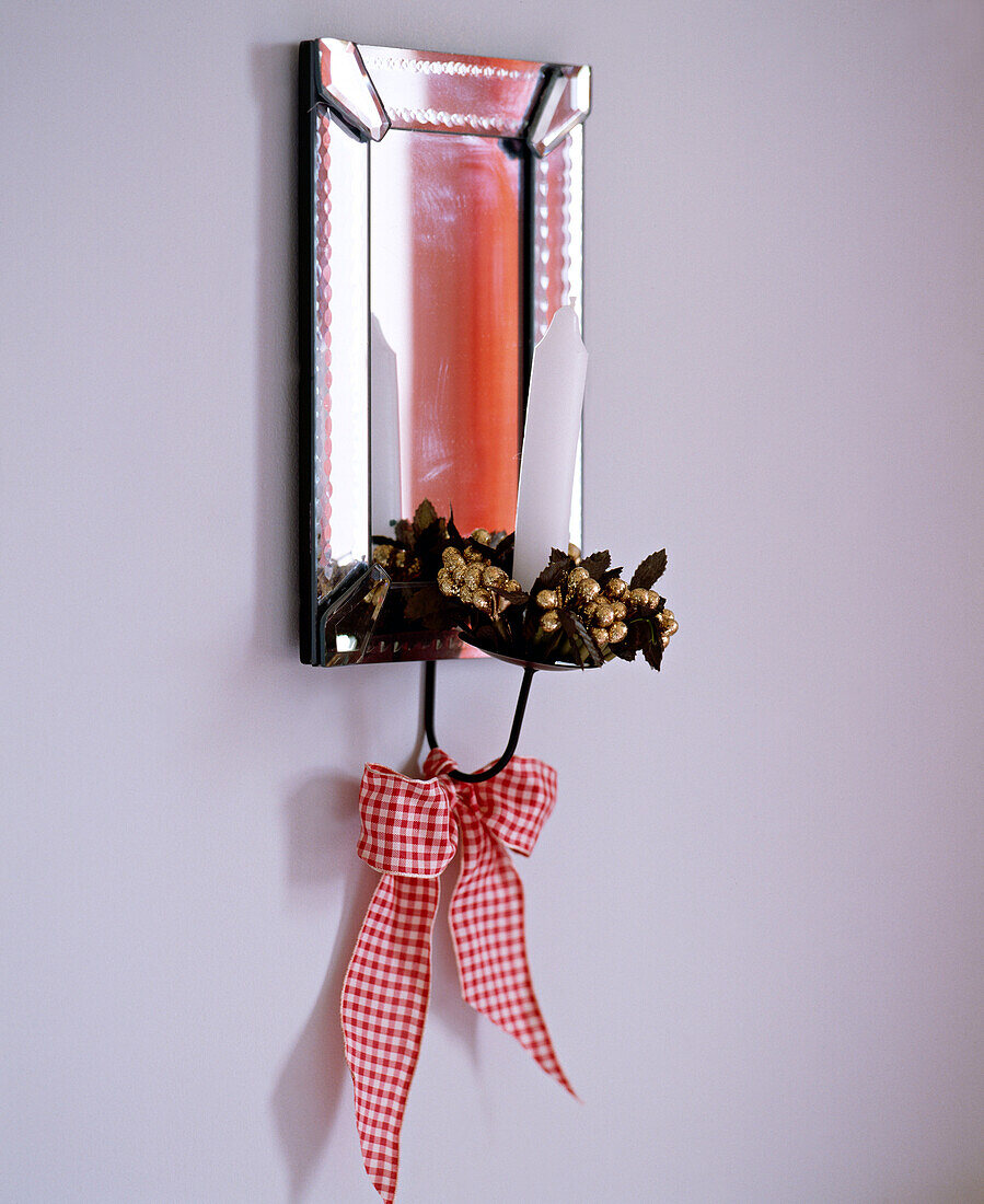 Detail eines verspiegelten Kerzenhalters mit einer Schleife im Gingham-Muster