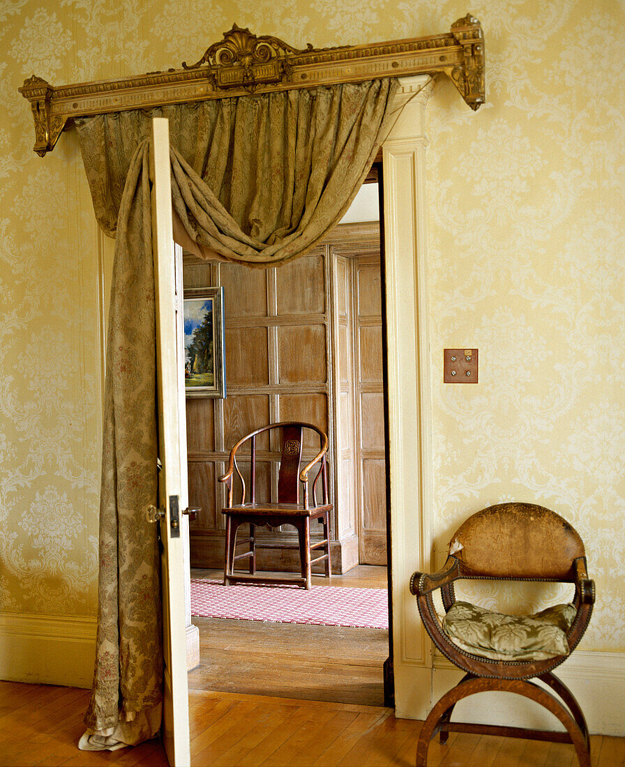 View through door with curtain to panelled hallway