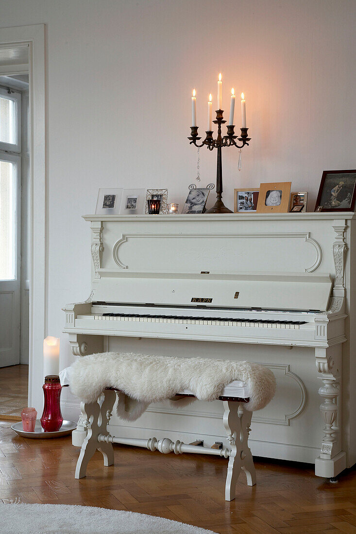 Kerzen auf einem weiß gestrichenen Klavier in einer Stockholmer Wohnung aus dem 20. Jahrhundert