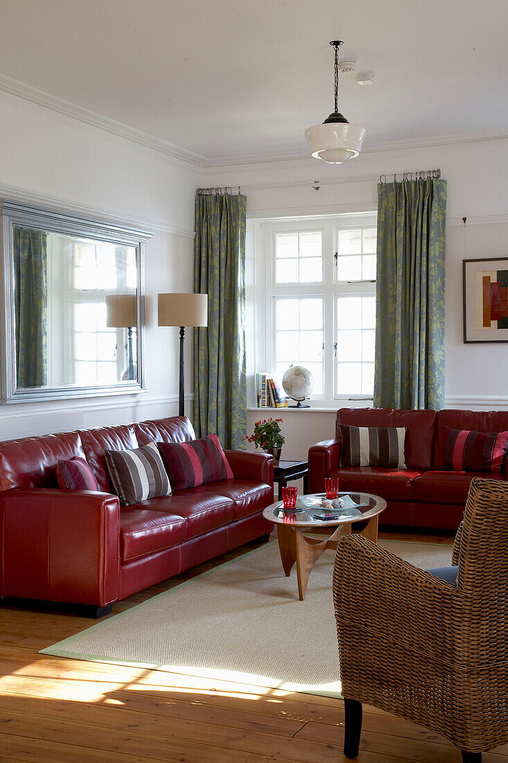 Red leather sofas in sunlit Devon living room