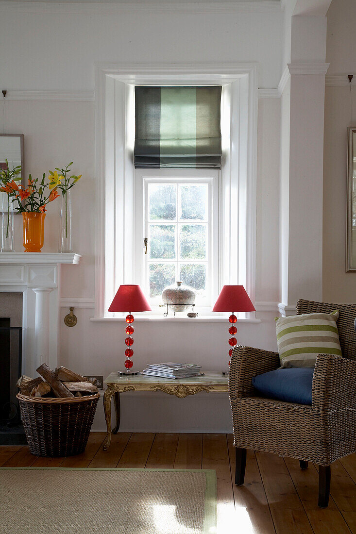 Matching red lamps at sunlit window of Devon living room