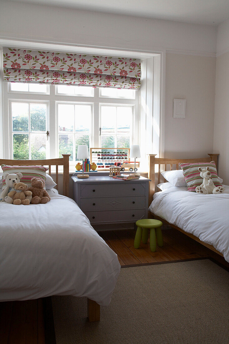 Zwillingsbetten in einem sonnenbeschienenen Kinderzimmer in Devon