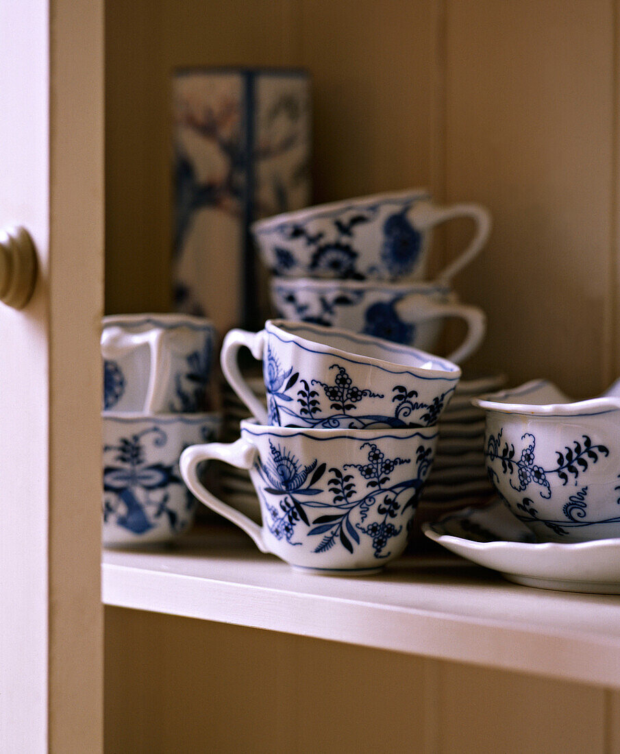 Blue and white china crockery in cupboard