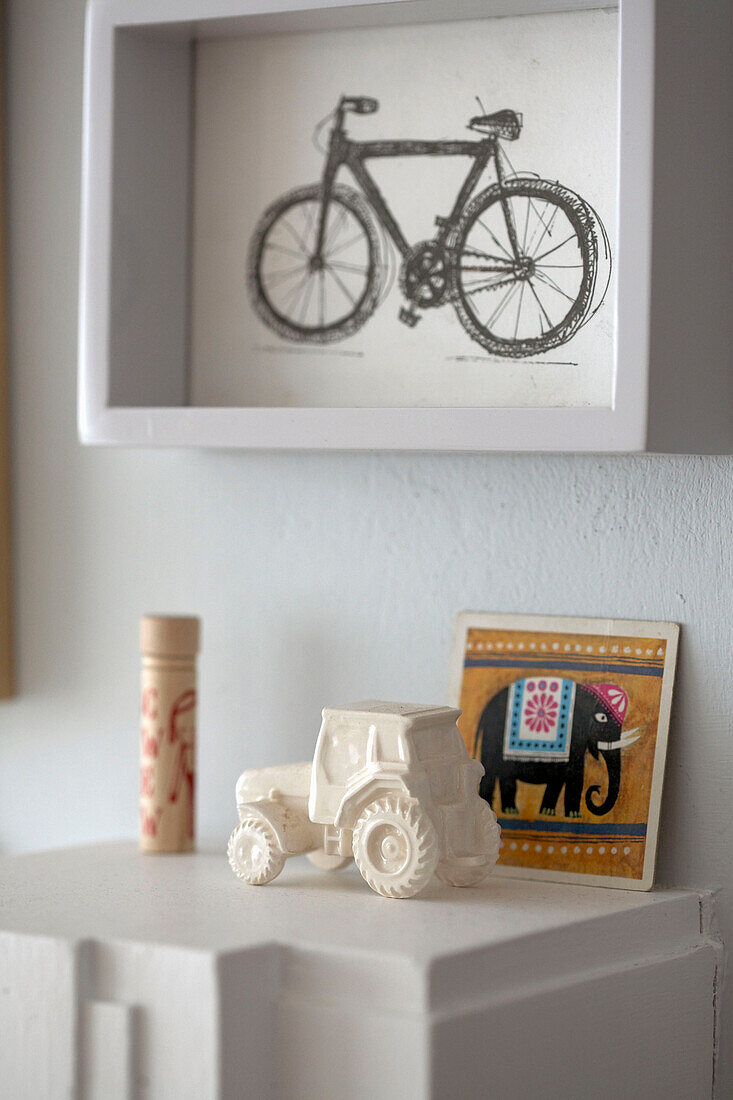 Bicycle artwork above model tractor with elephant card