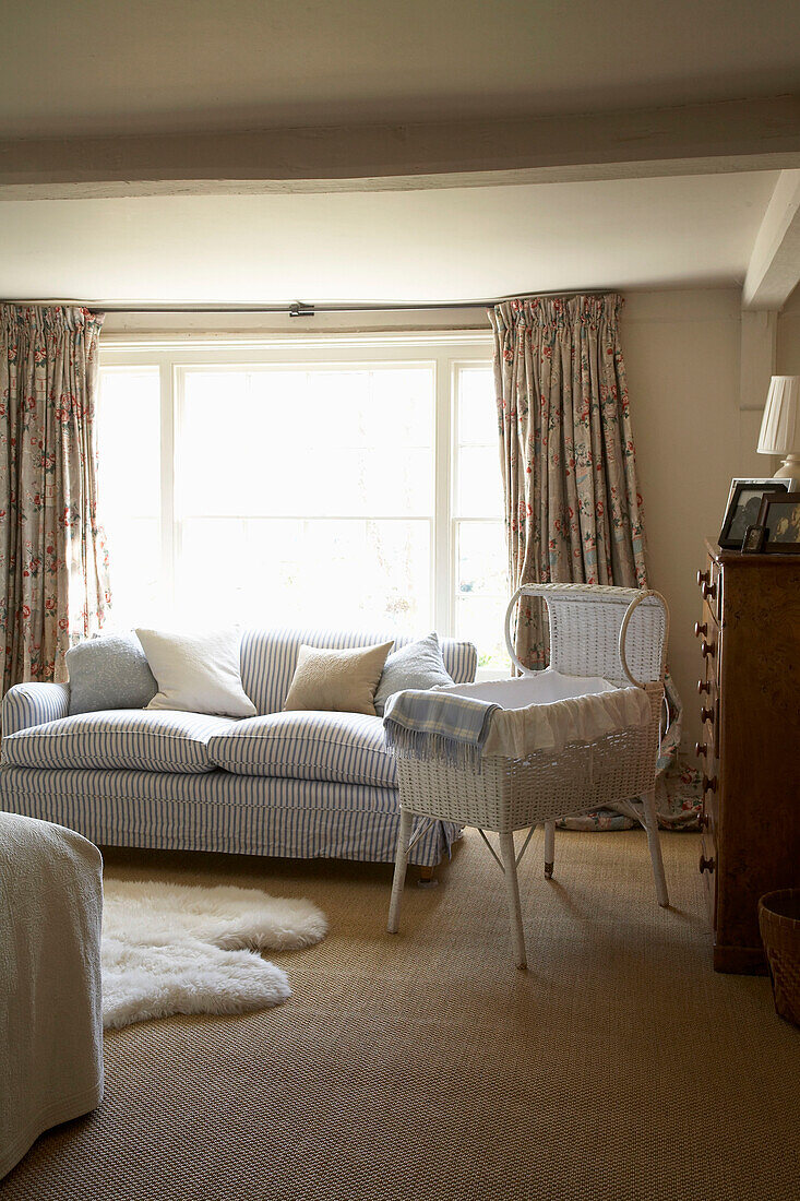 Painted crib in sunlit nursery with striped sofa in Rye, Sussex
