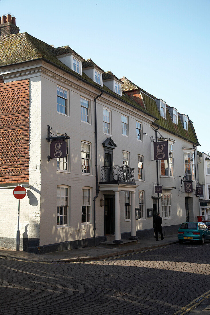 Weiß getünchte Fassade eines Gebäudes in einer gepflasterten Straße in Rye, Sussex