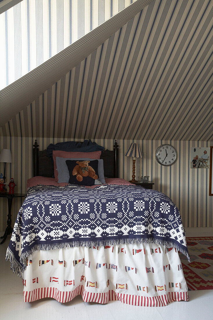 Kinderzimmer im Dachgeschoss mit gemustertem Bettbezug und Volant in Mariefred, Schweden