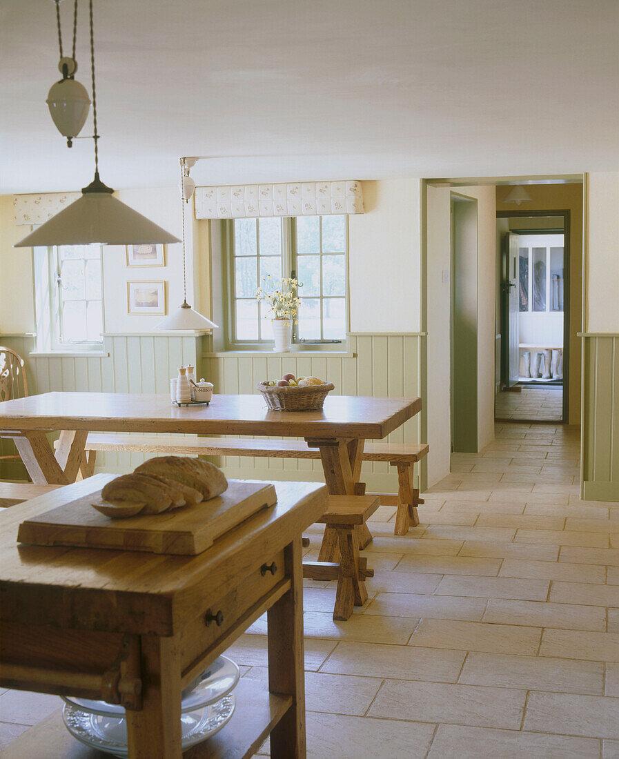 Küche im Landhausstil mit Steinboden und rustikalen Holztischen
