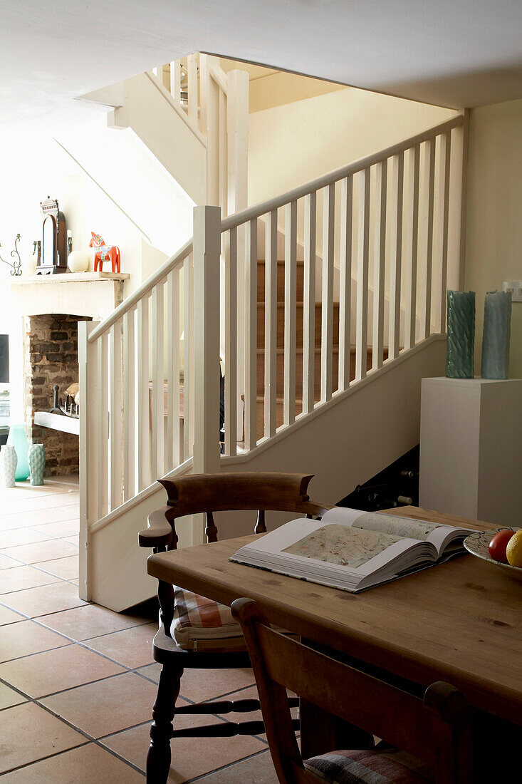 Wooden kitchen table with open book and banisters in Rye, Sussex