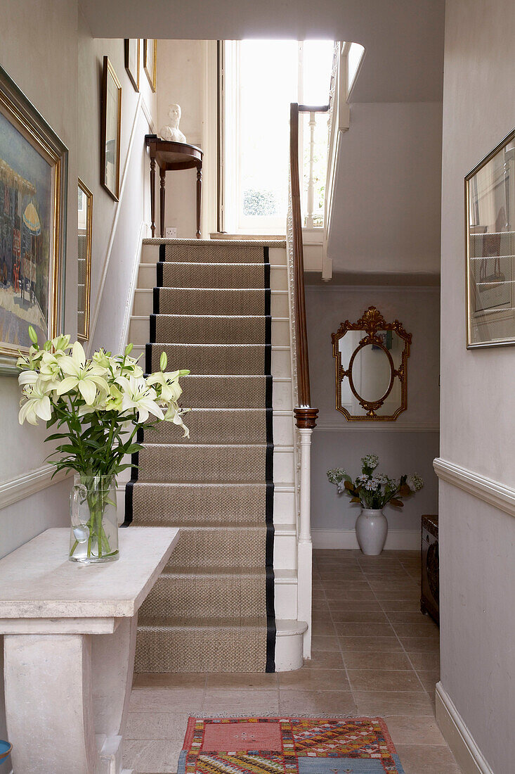 Cut flowers on marble console in Arundel entrance hallway, West Sussex