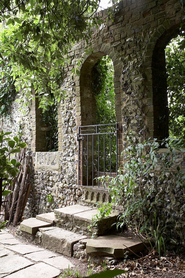 Courtyard garden with stone arches in Arundel, West Sussex