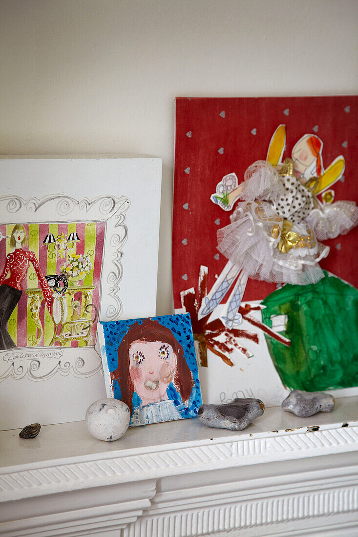 Children's drawings and pebbles on mantlepiece