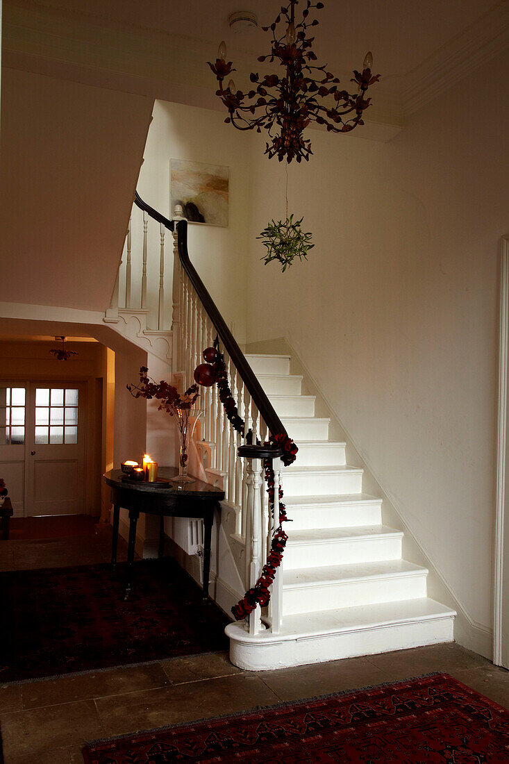 Christmas garland on banister and uncarpeted staircase