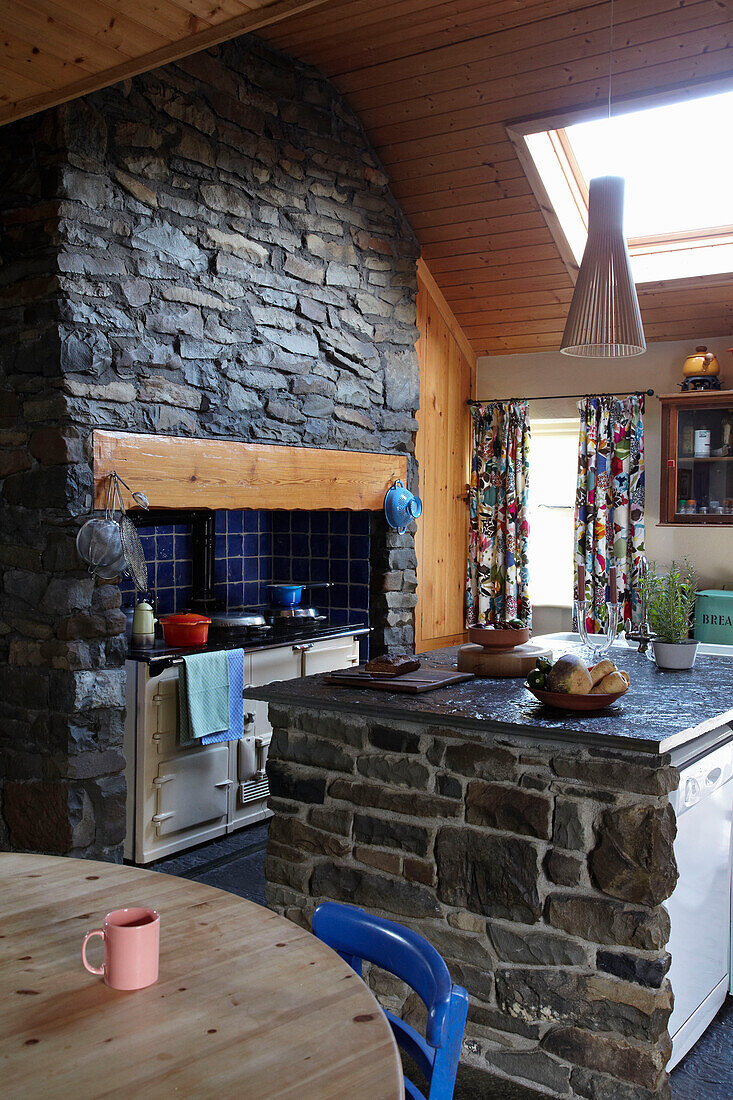 Bauernhausküche mit Sichtmauerwerk und Kücheninsel