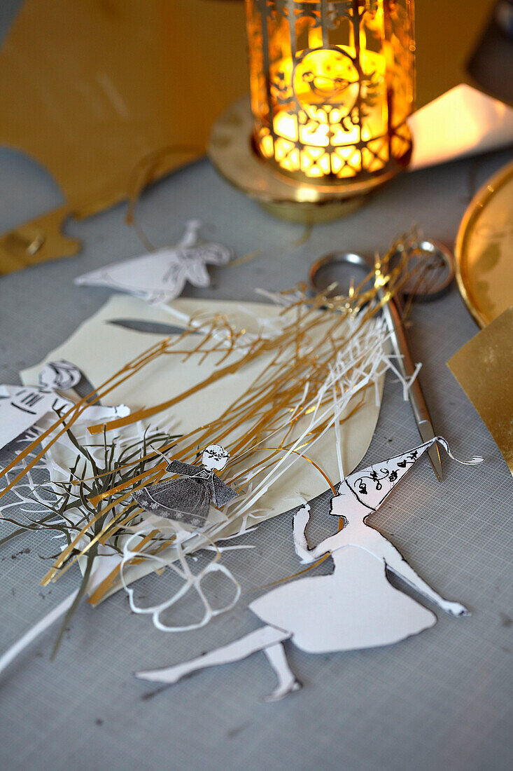 Paper decorations and scissors with lit candle