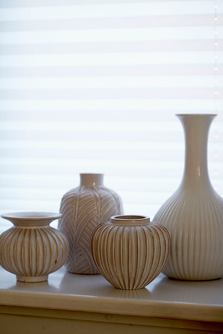 Decorative vases on window sill close-up